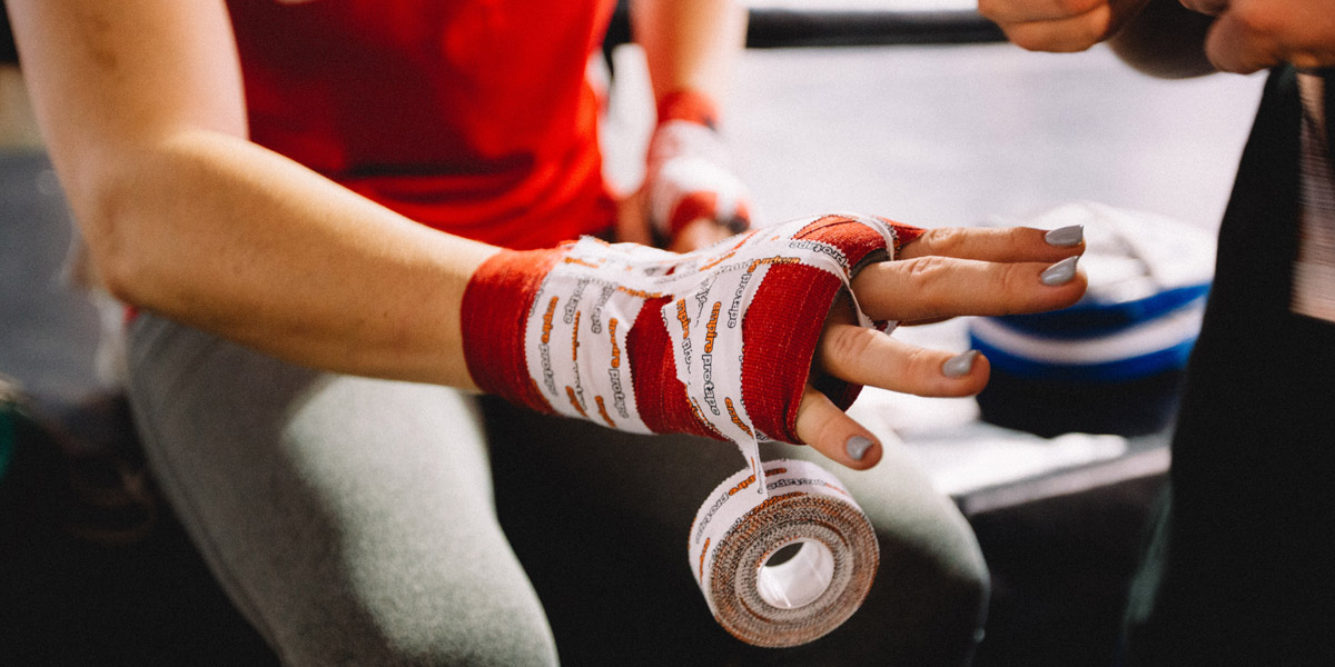 Hand wrapped in red gauze and tape in preparation for a fight